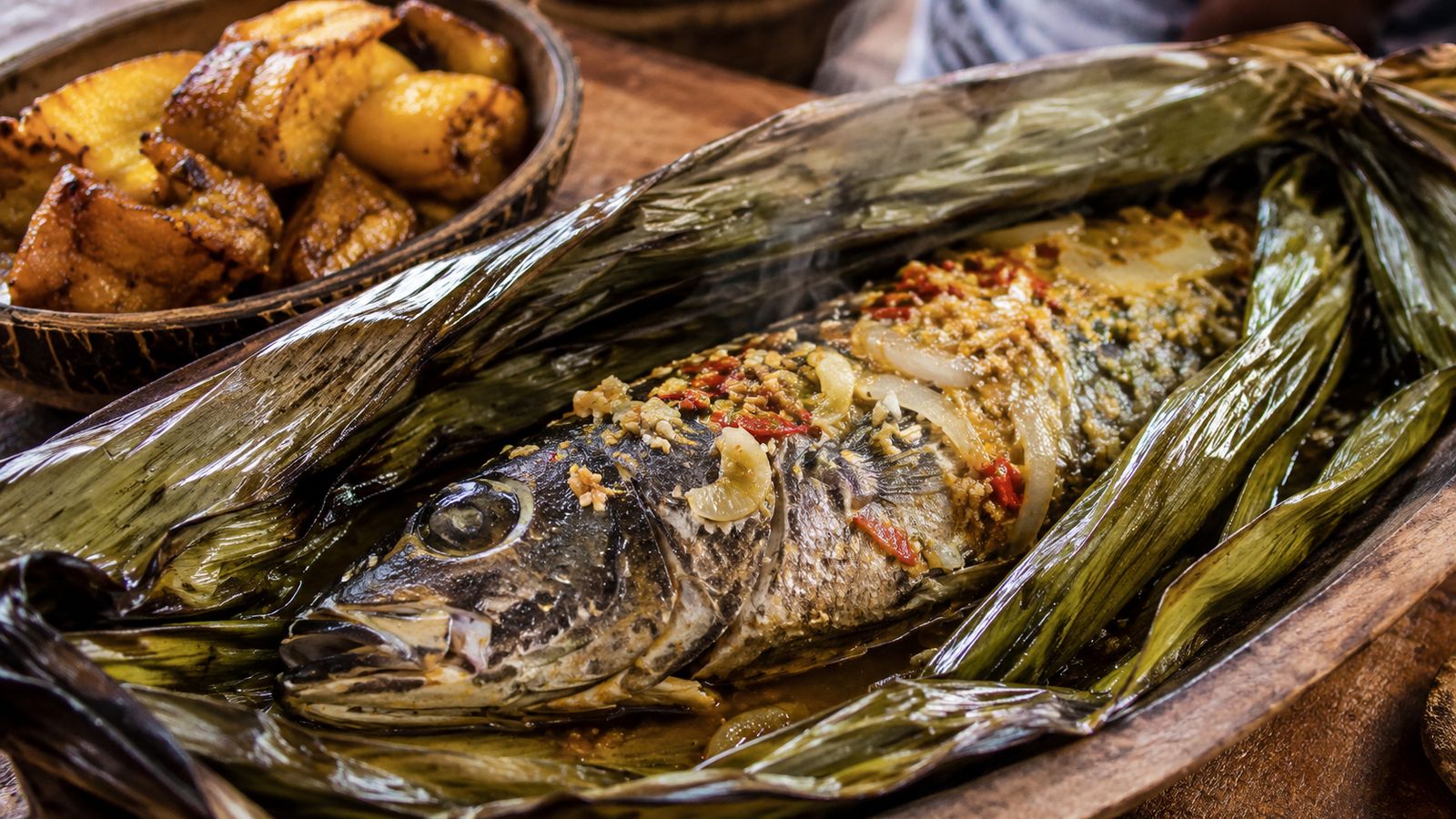 Maboké de Machoiron (poisson capitaine, machoiron ou silure mariné citron-ail-gingembre, enveloppé en papillote dans des feuilles de bananier ou de Marantaceae, cuit à l'étouffée sur braise de bois durs équatoriaux — technique-totem des Orungu Myènè de la côte gabonaise)